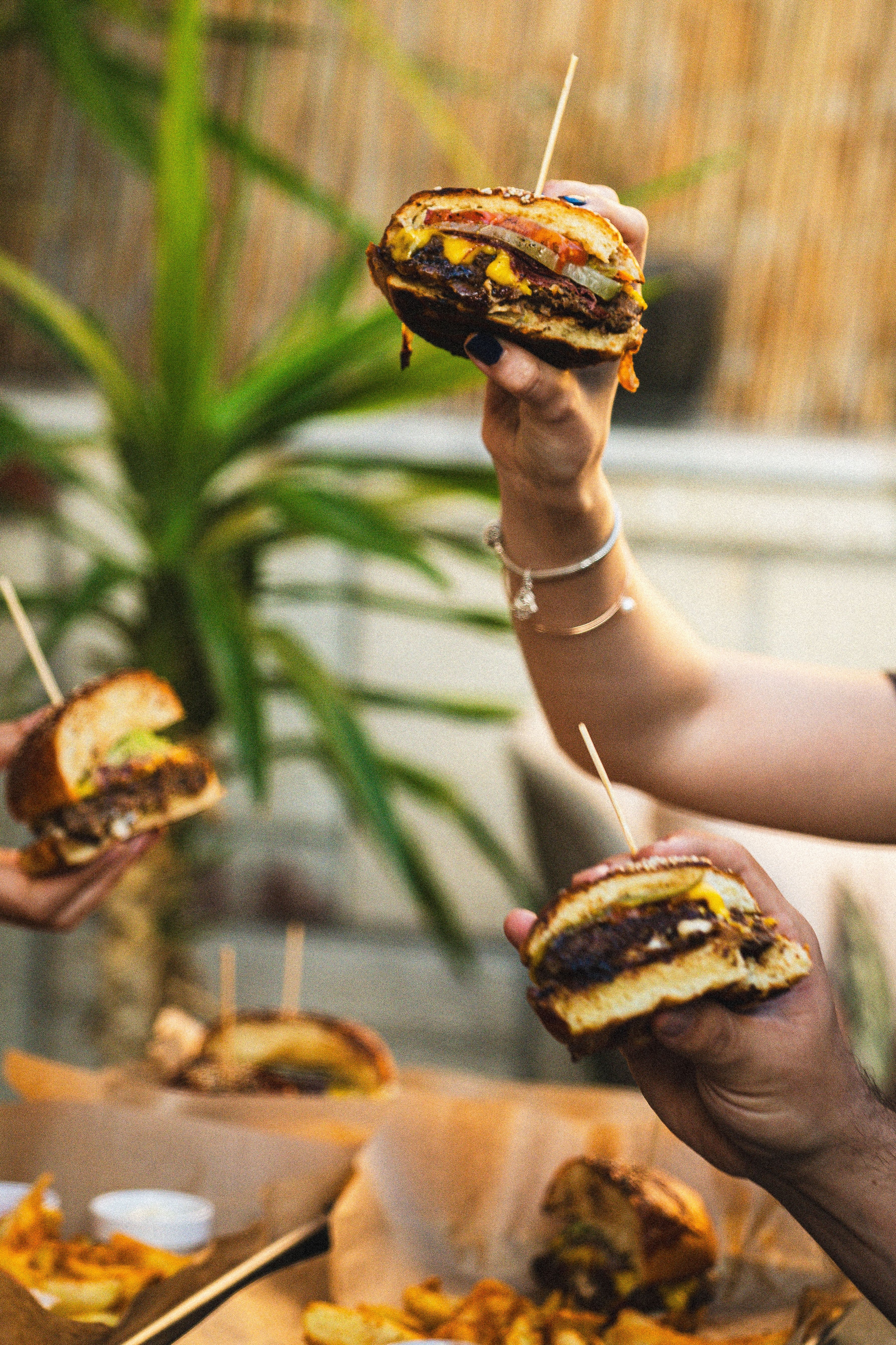 Customer photo: a hand holding a smash burger